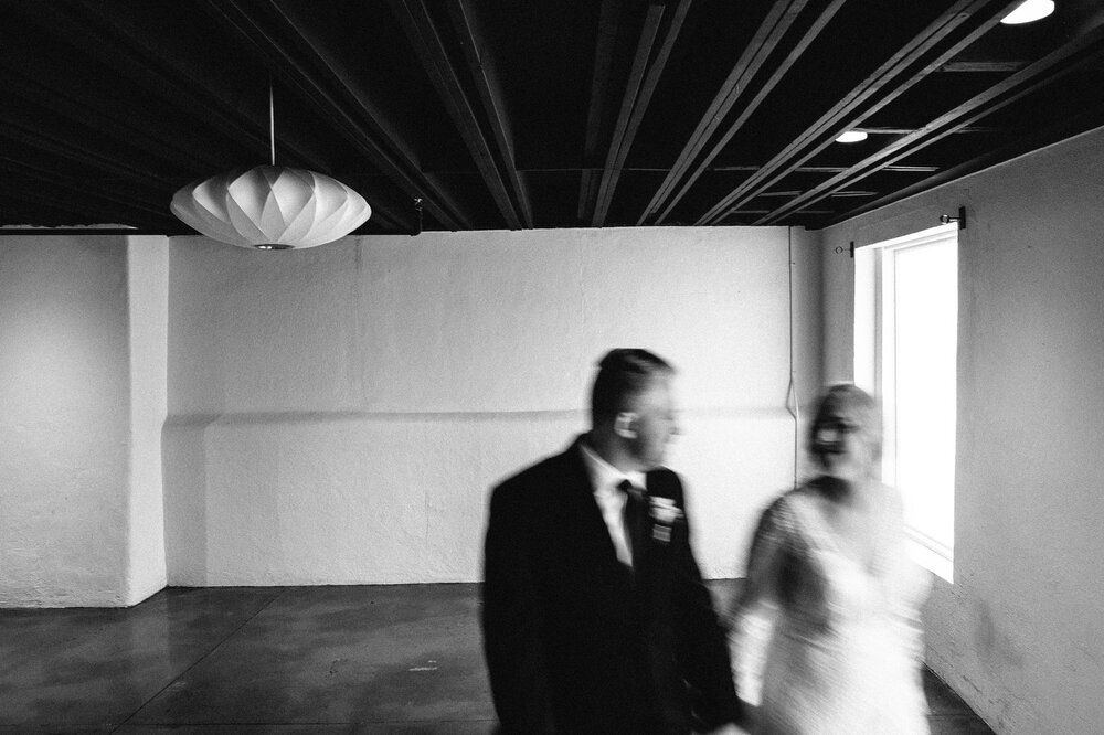 Moody black and white motion blur photo of bride and groom holding hands at Clementine Hall in Nashville, Tennessee.